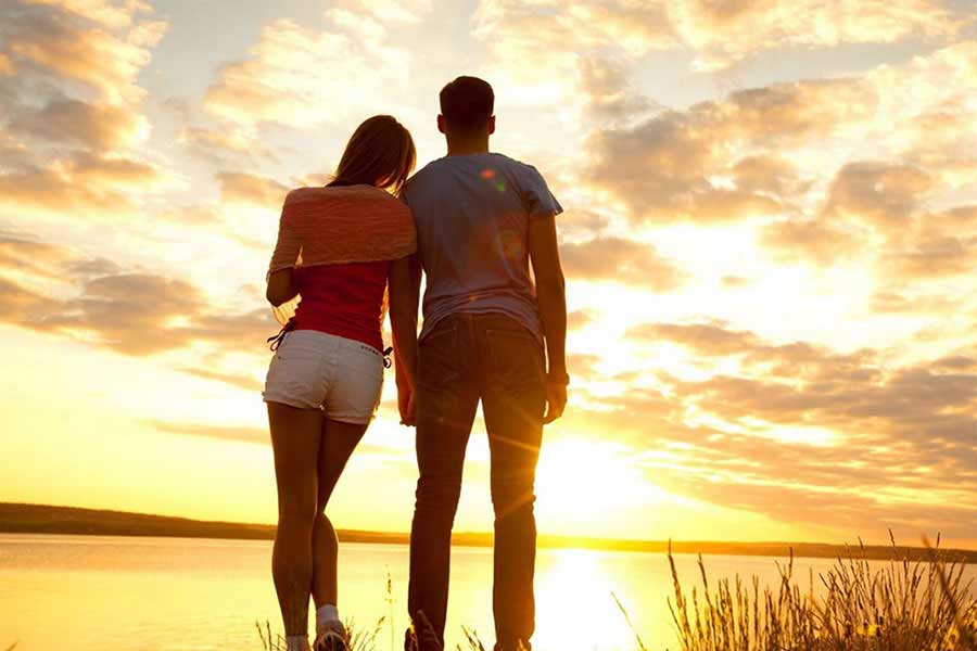 couple starring at sunset from hotel room