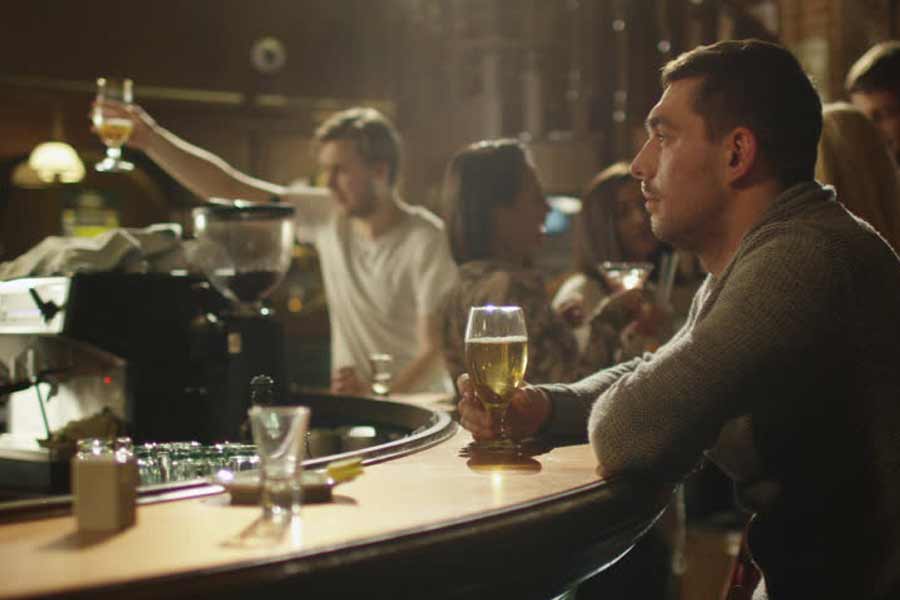 An addict getting drunk at bar